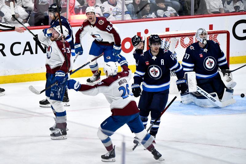 Colorado Avalanche's Yakov Trenin (73) celebrates his goal with teammates on Winnipeg Jets goaltender Connor Hellebuyck (37) during the second period in Game 5 of an NHL hockey Stanley Cup first-round playoff series in Winnipeg, Manitoba, Tuesday, April 30, 2024. (Fred Greenslade/The Canadian Press via AP)