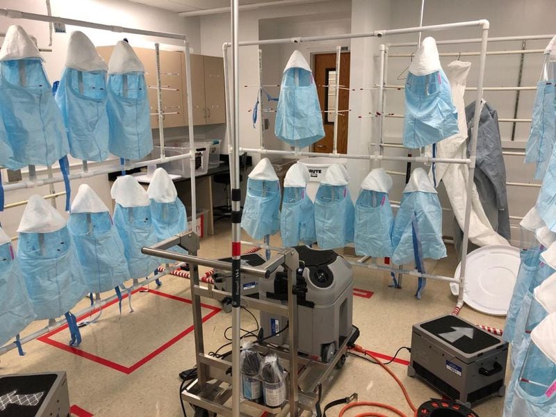 Protective hoods hang from racks at Emory University Hospital during a sterilization cycle using vaporized hydrogen peroxide. Emory is piloting a decontamination program to extend the life of single-use protective gear as hospitals face shortages fighting the coronavirus. SPECIAL TO THE AJC.