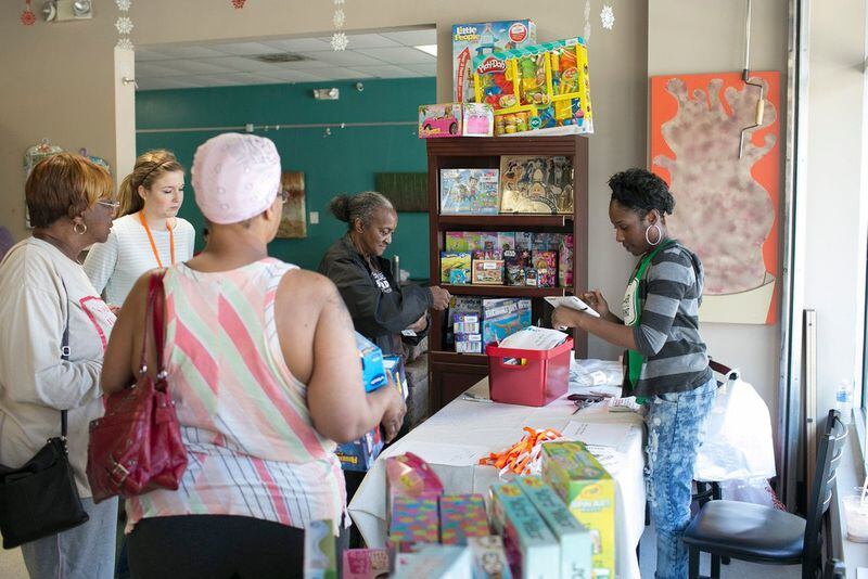 Carver Neighborhood Market employee Imani Willis checks out a customer at Pride for Parents. The holiday pop-up toy store provides South Atlanta residents the opportunity to buy toys the children in their families really want at a greatly reduced price. CONTRIBUTED BY BECCA STANLEY