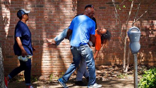 Family members carry a grief stricken Ebony Archie, mother of Kingston Frazier, after learning the young boy was found dead after being kidnapped during the theft of his mother's vehicle from a Kroger parking lot, Thursday, May 18, 2017, in Jackson, Miss. (Elijah Baylis/The Clarion-Ledger via AP)