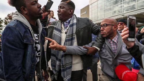 President Donald Trump supporters Tony Smith (right) of College Park and Jerrod Brown (center) of Savannah, get in a verbal shouting match with Anti-Trump protestor Chris Mungin (left) near the Georgia World Congress Center, Friday, November 8, 2019. (Alyssa Pointer)