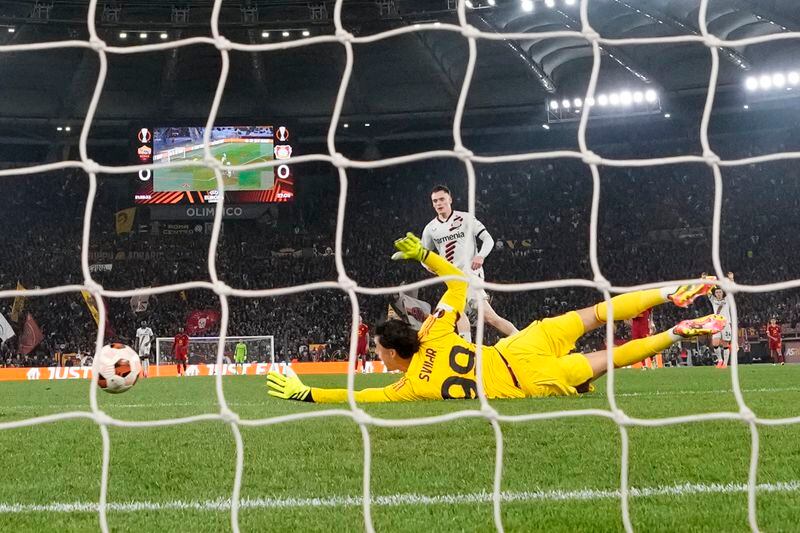 Roma's goalkeeper Mile Svilar, bottom, fails to save the ball as Leverkusen's Florian Wirtz, top, scores his side's opening goal during the Europa League semifinal first leg soccer match between Roma and Bayer Leverkusen at Rome's Olympic Stadium in Rome, Italy, Thursday, May 2, 2024. (AP Photo/Andrew Medichini)