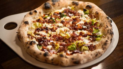 The Farmer's Market Pizza with mozzarella, brussels sprouts leaves, goat cheese, bacon bites, lemon zest, and bacon jam. Photo credit- Mia Yakel.