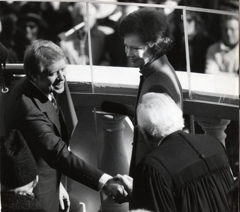 Rosalyn Carter watches as Jimmy Carter shakes hands with Justice Warren Burger at the Jan. 20, 1977, presidential inauguration.
