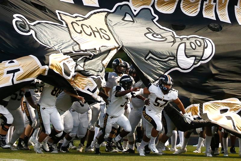 Colquitt County players break through their banner at the start of a high school football game Sept. 21, 2018, at Grayson High School in Loganville.