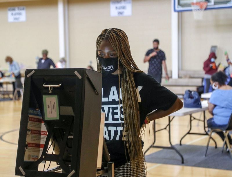 Smyrna resident Courtney Marshall wears a “Black Lives Matter” shirt while using the new electronic voting machine to cast her ballot at the Smyrna Community Center. ALYSSA POINTER / AJC