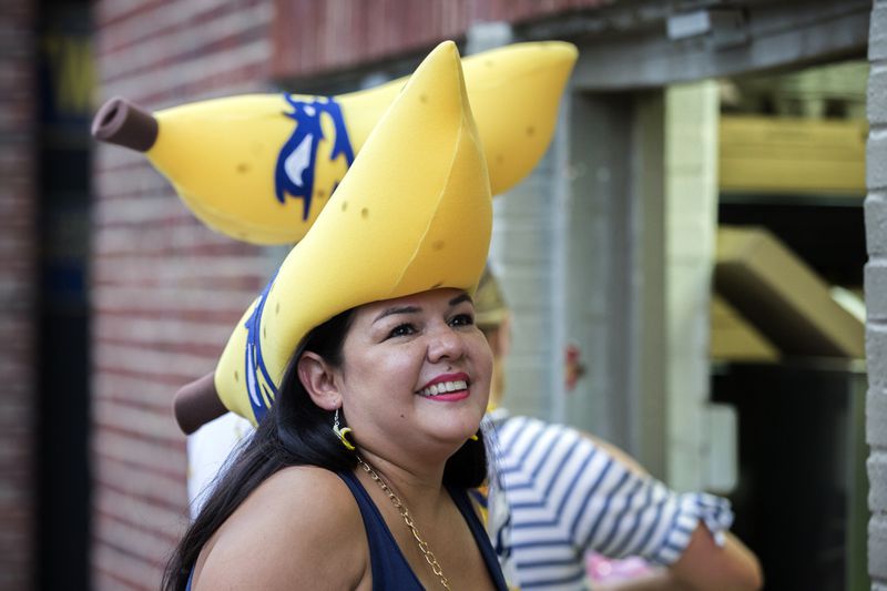 SAVANNAH, GA - JULY 12, 2022: Two Savannah Bananas fans dressed in foam banana hats wait inline at a concession stand before the start of a game with the Holly Springs Salamanders at Historic Grayson Stadium. (AJC Photo/Stephen B. Morton)