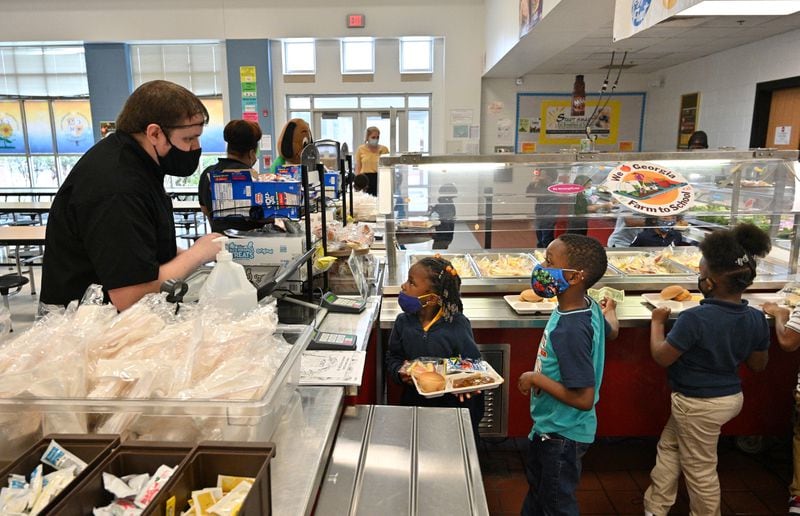 10월 13일 수요일 College Park에 있는 Cliftondale 초등학교의 학교 식당에서 식당 관리자인 Asher Keeney(왼쪽)가 유치원생들을 섬기고 있습니다. Metro Atlanta 학군은 전국적인 식량 공급 문제로 인해 메뉴를 수정하고 재작업하는 데 창의적이어야 합니다.  COVID-19 대유행으로 인해 지역은 일상적인 식품을 구하기가 어려워졌습니다.  (신효섭 / Hyosub.Shin@ajc.com)