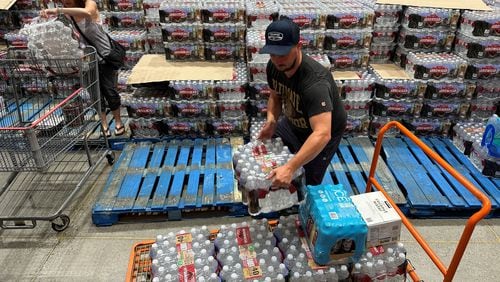 Home Depot has announced a deal that will allow Instacart customers to order Home Depot goods and have them delivered, potentially within hours. Here, a delivery driver loads cases of bottled water at a California Costco. (David Swanson/AFP/Getty Images/TNS)