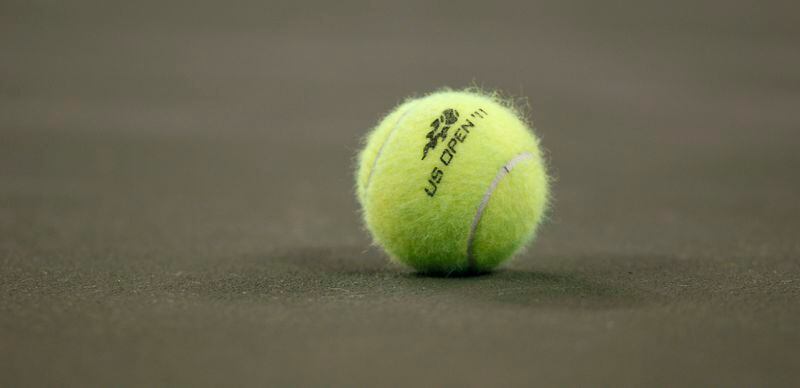 FILE - A tennis ball on the court during the first round of the U.S. Open tennis tournament in New York, Tuesday, Aug. 30, 2011. A tennis player has been awarded $9 million in damages by a jury in federal court in Florida after accusing the U.S. Tennis Association of failing to protect her from a coach she said sexually abused her at one of its training centers when she was 19. (AP Photo/Charles Krupa, File)