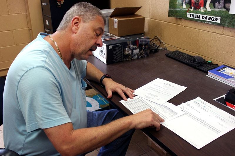 Greensboro, Ga., resident Michael Rowe looks through research he did about Confirmatrix Laboratory Inc. after he started receiving calls from a debt collector saying he owed past due lab fees. JENNA EASON / JENNA.EASON@COXINC.COM