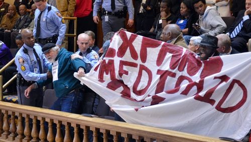 About 20 “Moral Monday” protesters were arrested at the state Capitol in March 2014 after disrupting the Senate by shouting and holding signs calling for Medicaid expansion. Georgia is one of 19 states that has refused to expand Medicaid under the Affordable Care Act. BRANT SANDERLIN /BSANDERLIN@AJC.COM