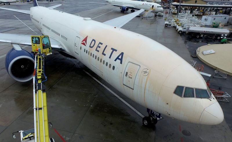 In a demonstration of how Delta planes go through a process of deicing in frigid whether, a worker sprays a colored solution on the entire plane before it can take off. 