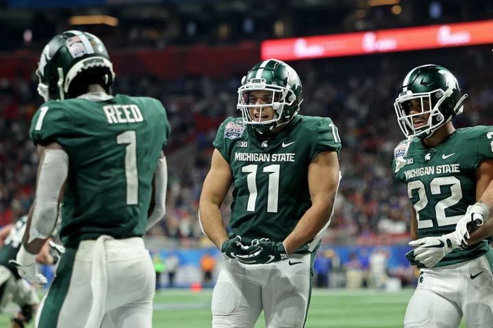 Michigan State Spartans wide receiver Jayden Reed (1) celebrates his go-ahead touchdown with tight end Connor Heyward (11) in the fourth quarter against the Pittsburgh Panthers in the Chick-fil-A Peach Bowl at Mercedes-Benz Stadium in Atlanta, Thursday, December 30, 2021. Heyward is a graduate of Peachtree Ridge high school. JASON GETZ FOR THE ATLANTA JOURNAL-CONSTITUTION