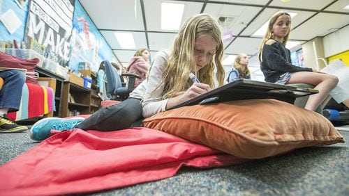 Amanda Garrett, 9, works on a project while lying on a mat during a fourth-grade class at Anderson Elementary School in Newport Beach, California. Contributed by Scott Smeltzer/Los Angeles Times/TNS
