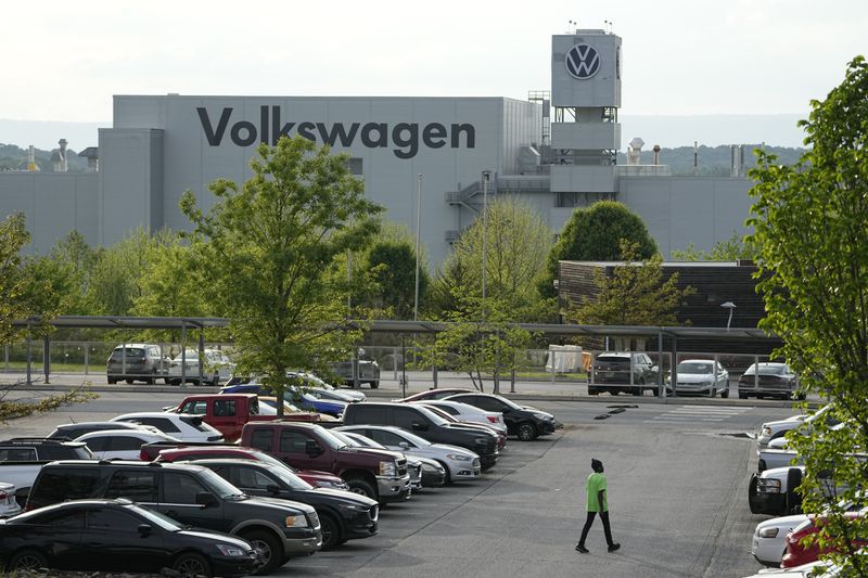 A person walks across the parking lot at the Volkswagen automobile plant in Chattanooga, Tenn., Friday, April 19, 2024. Workers at the plant finish voting Friday night on whether to join the United Auto Workers union. (AP Photo/George Walker IV)