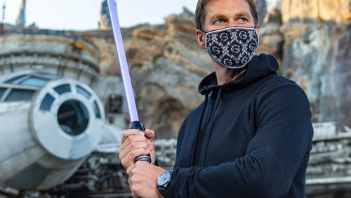 In this photo provided by Walt Disney World, Bucs quarterback Tom Brady visits Star Wars: Galaxy's Edge inside Disney's Hollywood Studios. A mask-wearing Brady visited the "Star Wars"-themed section of Walt Disney World with his family and friends, two months after he led the Bucs to a Super Bowl win against the Chiefs. (Matt Stroshane/Disney World via AP)