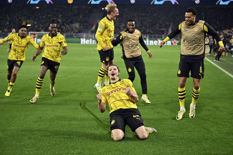 Dortmund's Marcel Sabitzer, center, celebrates his side's fourth goal during the Champions League quarterfinal second leg soccer match between Borussia Dortmund and Atletico Madrid at the Signal-Iduna Park in Dortmund, Germany, Tuesday, April 16, 2024. (Bernd Thissen/dpa via AP)