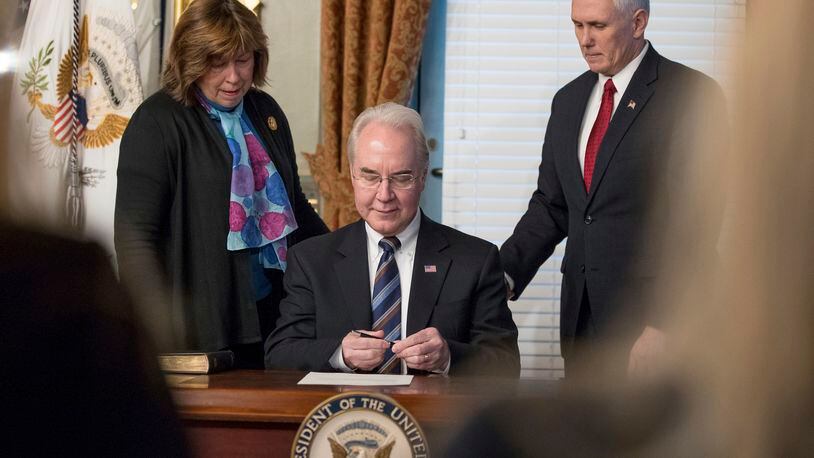 Health and Human Services Secretary Tom Price, center, accompanied by his wife Betty, and Vice President Mike Pence, signs an official document during a swearing in ceremony, Friday, Feb. 10, 2017, in the in the Eisenhower Executive Office Building on the White House complex in Washington. (AP Photo/Andrew Harnik)