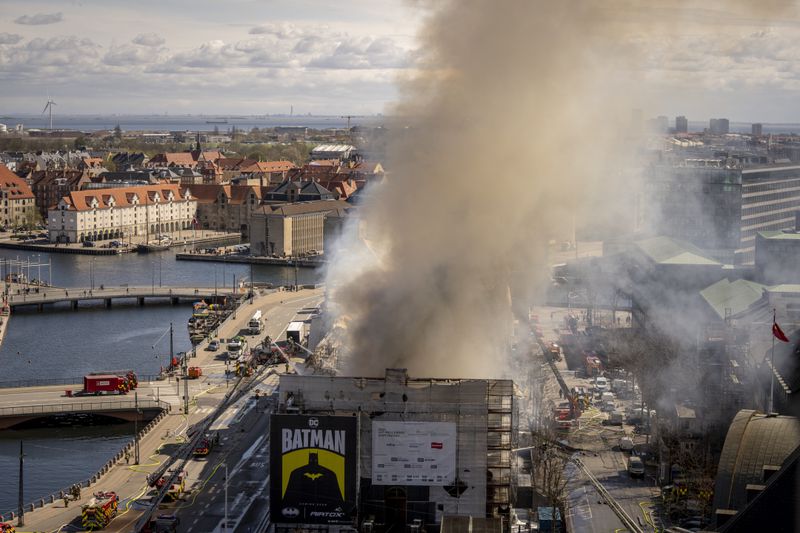 Smoke rises from the Stock Exchange in Copenhagen, Denmark, Tuesday, April 16, 2024. A fire raged through one of Copenhagen’s oldest buildings on Tuesday, causing the collapse of the iconic spire of the 17th-century Old Stock Exchange as passersby rushed to help emergency services save priceless paintings and other valuables. (Ida Marie Odgaard/Ritzau Scanpix via AP)