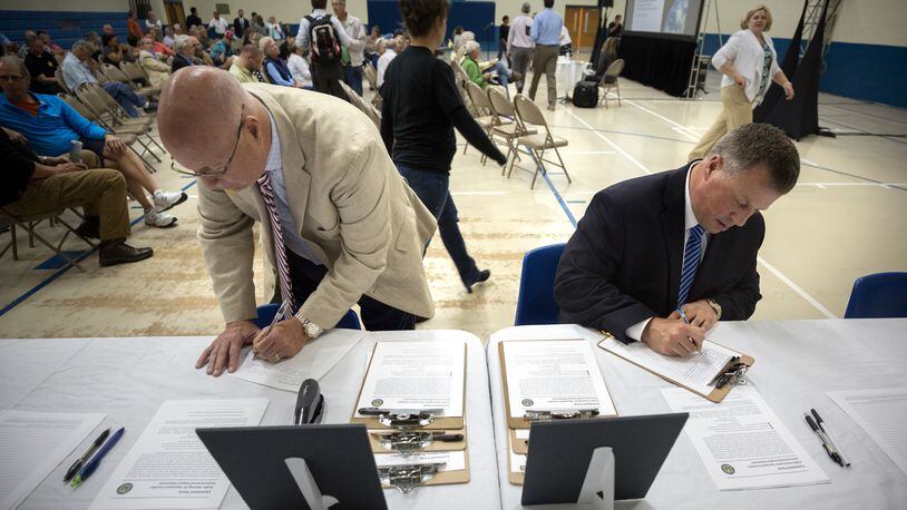 Two Glynn County residents fill out comment cards during a public hearing to discuss the Federal Aviation Administration’s recently released environmental impact study about the potential site for a spaceport in Kingsland. (AJC Photo/Stephen B. Morton)