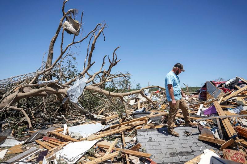 Paden Fincher looks to salvage items from what's left of his sister's home following a severe storm, Tuesday, May 7, 2024 in Barnsdall, Okla. Fincher said his sister, her husband and their 3 children rode the storm out in the home. He said his sister was in surgery, but said she was going to be ok. A tornado destroyed homes, forced the evacuation of a nursing home and toppled trees and power lines when it roared through the small Oklahoma town. (Mike Simons/Tulsa World via AP)