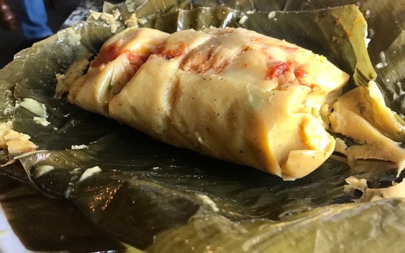 The Tamal Colombiano at El Kiosco in Marietta is made from corn masa and filled with chunks of pork, chicken, chorizo and beef, served atop a plantain leaf. LIGAYA FIGUERAS / LFIGUERAS@AJC.COM