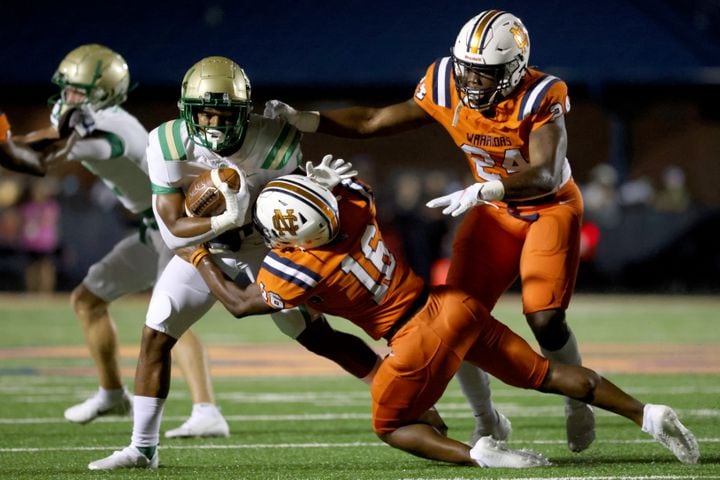 August 20, 2021 - Kennesaw, Ga: Buford running back CJ Clinkscales (5) is tackled by North Cobb linebacker Kameron Owens(16) and linebacker Jeremiah Jones (24) during the first half at North Cobb high school Friday, August 20, 2021 in Kennesaw, Ga.. JASON GETZ FOR THE ATLANTA JOURNAL-CONSTITUTION