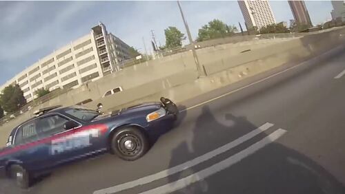 This still image shows the shadow of the motorcyclist and a pursuing Atlanta police officer. The motorcyclist sped off and weaved through traffic, leaving the officer in the dust.