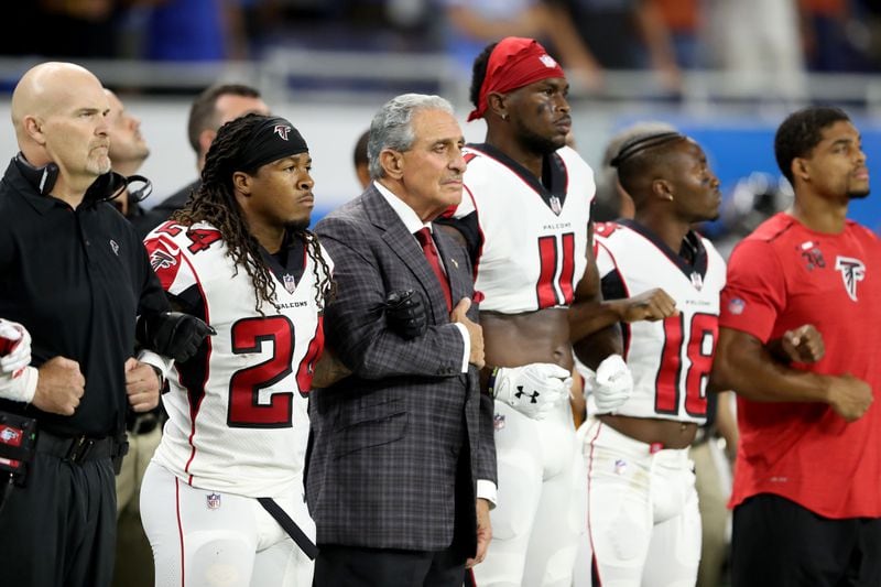 Falcons owner Arthur Blank joins arms with his players during the playing of the national anthem prior to the game against the Detroit Lions at Ford Field on September 24, 2017 in Detroit, Michigan. (Photo by Leon Halip/Getty Images)
