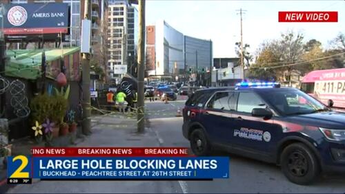 A sinkhole on Peachtree Street in Buckhead swallowed the sign for Sufi's Kitchen on Monday.