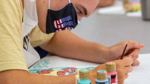 St. Pius X Catholic School football player Jimmy Brady paints "Heart Boards" to show his support & appreciation in August to healthcare worker during the pandemic.PHIL SKINNER FOR THE ATLANTA JOURNAL-CONSTITUTION.