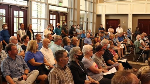 Nearly 50 residents, mostly wearing blue, packed into Suwanee City Hall on Tuesday to question and oppose an amendment to the city's zoning ordinance. (Tyler Wilkins / tyler.wilkins@ajc.com)