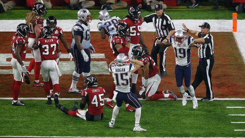 The exact moment Atlanta's heart broke: New England celebrates James White's overtime touchdown while the Falcons contemplate the title that got away. (Bob Levey/Getty Images)