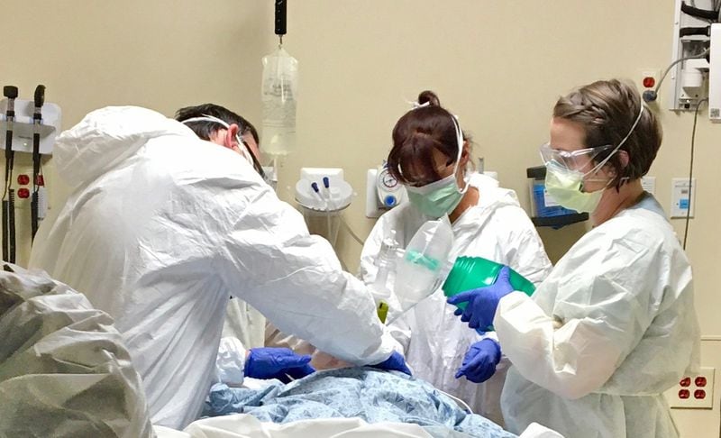Dr. Joseph Funk, Dr. Kathleen Funk and Sara Tettelbach, a registered nurse, caring for a critical patient at Northside Hospital amid rising COVID-19 cases. (Handout photo taken in March 2020)