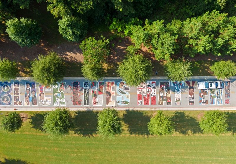An aerial photo shows a giant colorful mural on the driveway of Drew Charter School Junior/ Senior Academy on Tuesday, Aug. 24, 2021. In this side of the mural, each letter of “Black Lives Matter” depicts an aspect of Black life in America. (Hyosub Shin / Hyosub.Shin@ajc.com)