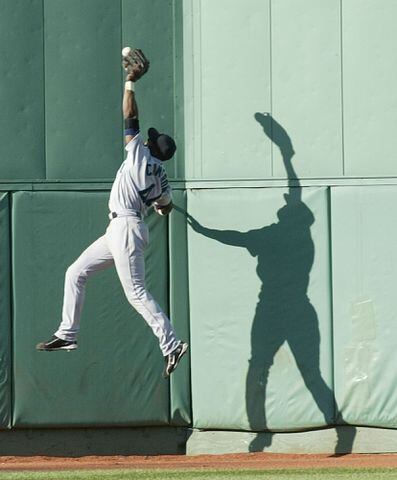 Baseball players battle the ball and the wall