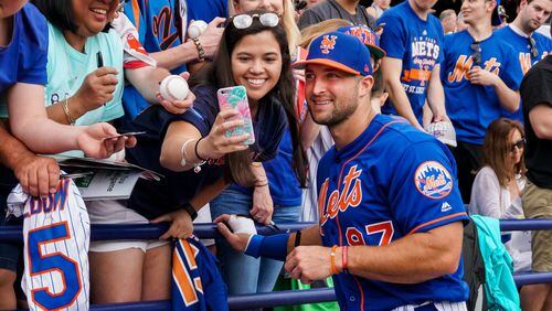 Tim Tebow poses with fans before the Mets game against Boston on Wednesday. (Richard Graulich / The Palm Beach Post)