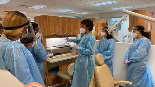 Atlanta Technical College instructor Krishana Cureton (center) talks to students about procedures to prepare patients for treatment in her dental hygiene class. ERIC STIRGUS / ERIC.STIRGUS@AJC.COM