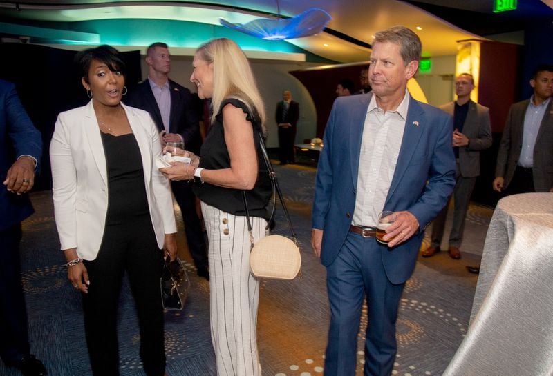 Mayor of Atlanta Keisha Lance Bottoms (left) and Georgia Governor Brian Kemp (right) talk with others before the start of Bernie Marcus’s 90th birthday party and fundraiser at the Georgia Aquarium on Sunday. 