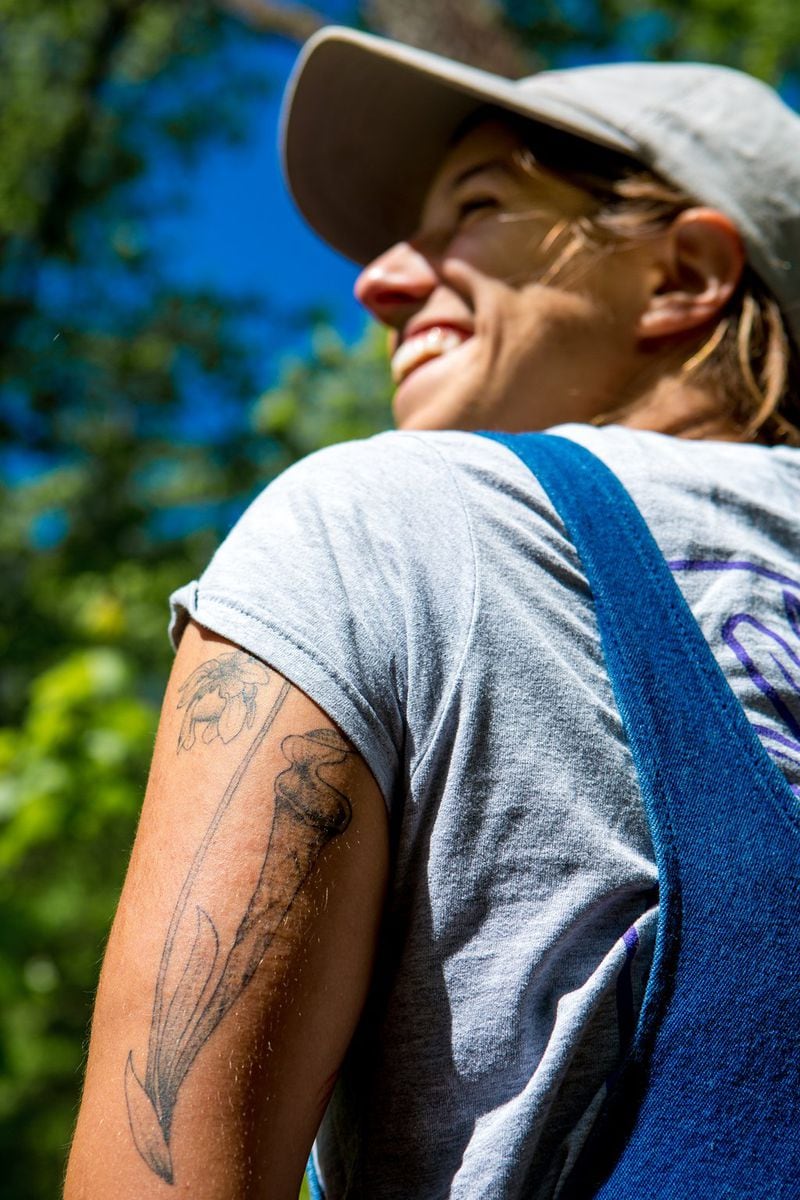 Carly Evans, 23, a graduate assistant with the State Botanical Garden of Georgia in Athens, shows her horticultural affinities with her tattoo of a green pitcher plant. She was among those working recently to help preserve the wild population of the purple pitcher plant in North Georgia. (Casey Sykes for The Atlanta Journal-Constitution)
