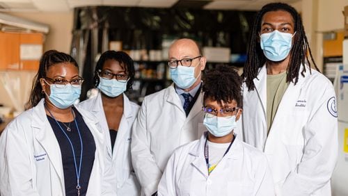 Morehouse School of Medicine chief scientific research officer, Dr. Gianluca Tosini, center, with students.