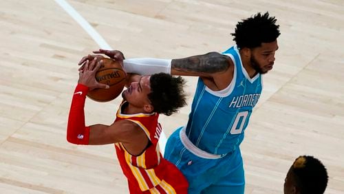 Hawks guard Trae Young, left, tries to drive past Charlotte Hornets forward Miles Bridges (0) during the first half of an NBA basketball game Wednesday, Jan. 6, 2021, in Atlanta. (AP Photo/John Bazemore)