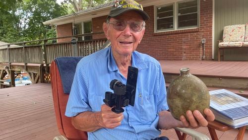 World War II vet Robert Ford, 97, shows a Japanese gun sighting and canteen that he found in caves while trying to find stragglers on the island of Saipan in World War II. He was on the island while American forces tried without success to capture Japanese Capt, Sakae Ōba, who surrendered with a small force 3 months after the war was over.