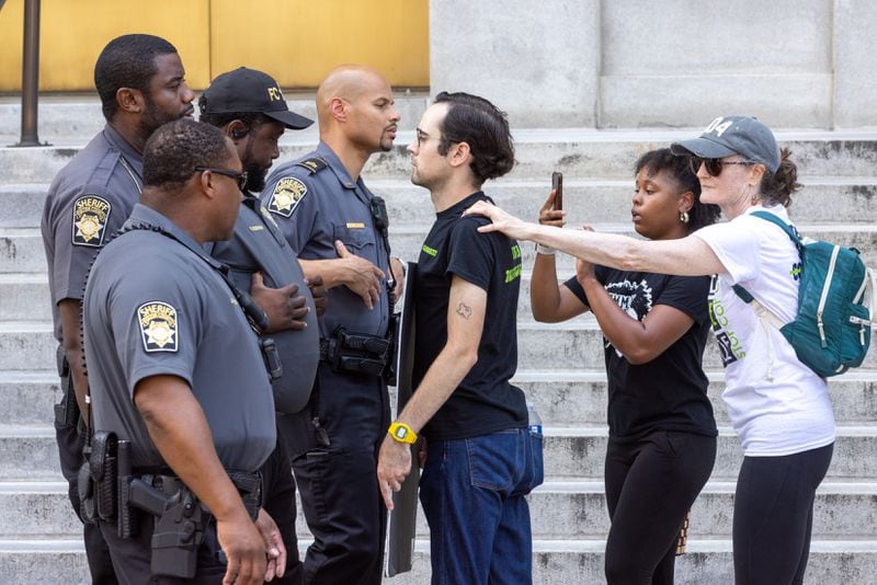 Protestors against Atlanta’s planned public safety training center clash with sheriff's deputies outside Fulton County Courthouse in Atlanta on Monday as Fulton prosecutors present their election interference case against former President Donald Trump and others to a grand jury.