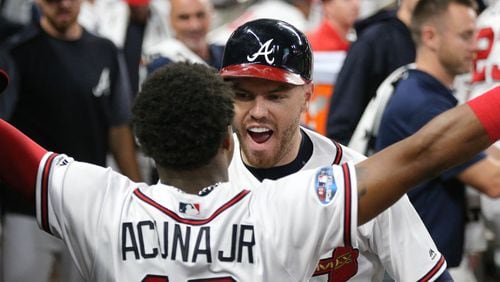Braves first baseman Freddie Freeman celebrates his solo home run with left fielder Ronald Acuna in Game 3 of the National League Division Series Sunday, Oct. 7, 2018, in Atlanta.