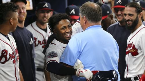 Atlanta Braves rookie second baseman Ozzie Albies embraces trainer Jim Lovell after hitting a three-run home run during the ninth inning of the team’s baseball game against the Los Angeles Dodgers on Thursday, Aug. 3, 2017, in Atlanta. The Dodgers won 7-4. The homer is Albies’ first hit in the majors. (AP Photo/John Bazemore)