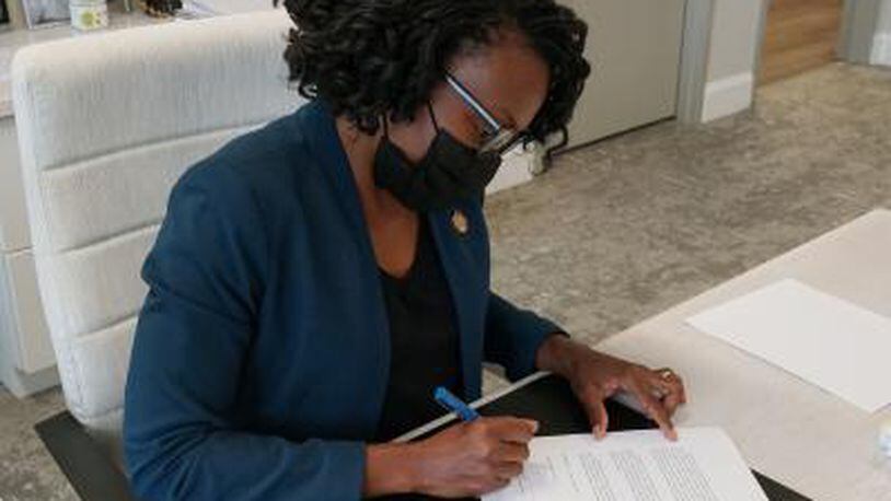 Cobb County Chairwoman Lisa Cupid signs an order last year declaring the county in a State of Emergency due a surge in COVID-19 cases. The latest emergency order was renewed this month. (Photo courtesy of Cobb County)