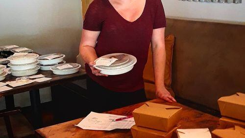 Katie Lewis, executive director of the Tzedakah Project, prepares meals as part of the Elephant Initiative. CONTRIBUTED