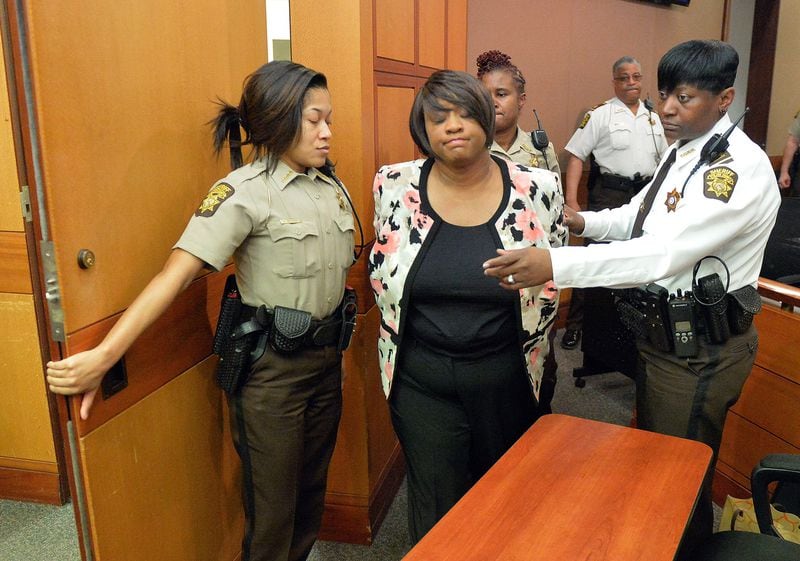 Former Atlanta Public Schools school reform team director Tamara Cotman, center, is led to a holding cell after a jury found her guilty in the Atlanta Public Schools test-cheating trial. Cotman was one of 11 educators convicted in the case and another 21 pleaded guilty. (AP Photo/Atlanta Journal-Constitution, Kent D. Johnson, Pool)